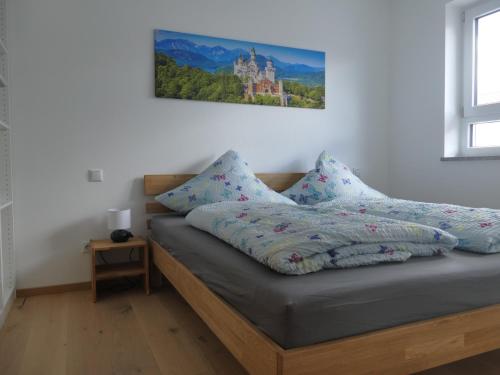 Ferienwohnung an der Ach في Oberhausen: غرفة نوم بسرير مع لوحة على الحائط