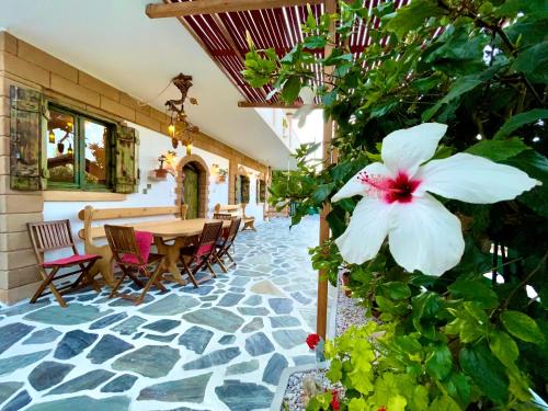 d'une terrasse avec une table et une fleur blanche. dans l'établissement Village Villa Marika - Mimis Drapanias, à Dhrapaniás
