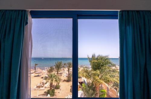 a window with a view of the beach and the ocean at Lagoonie Lodge & Beach in Hurghada