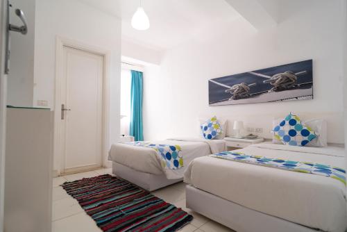 a white room with two beds and a couch at Lagoonie Lodge & Beach in Hurghada