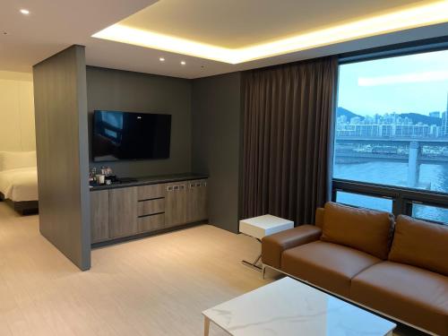a living room with a couch and a large window at AG405 Hotel in Busan