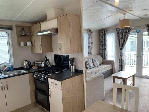 eine kleine Küche und ein Wohnzimmer in einem Wohnwagen in der Unterkunft Bude holiday home in Bude