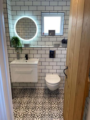 a bathroom with a toilet and a sink and a mirror at Beechwood Nook- Crown Lodges in Crawshaw Booth