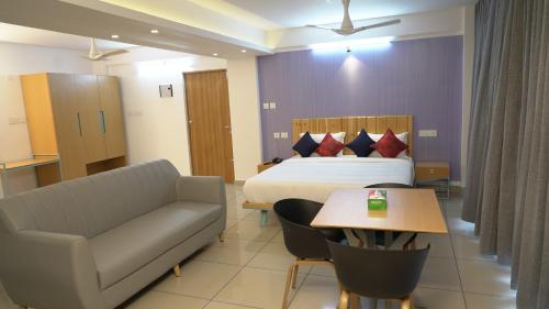 a hotel room with a bed and a couch and a table at The White Orchid Luxury Service Apartments in Ernakulam