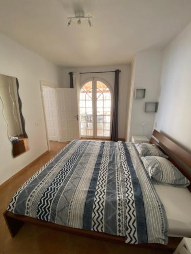 Una cama grande en un dormitorio con ventana. en Villa One Tenerife, en Costa del Silencio
