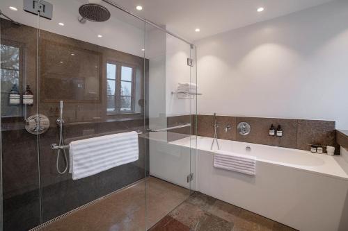 ein Badezimmer mit einer Dusche, einer Badewanne und einem Waschbecken in der Unterkunft Dragsholm Slot in Hørve