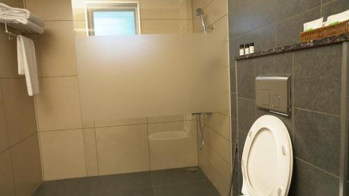 a bathroom with a toilet and a shower at The White Orchid Luxury Service Apartments in Ernakulam