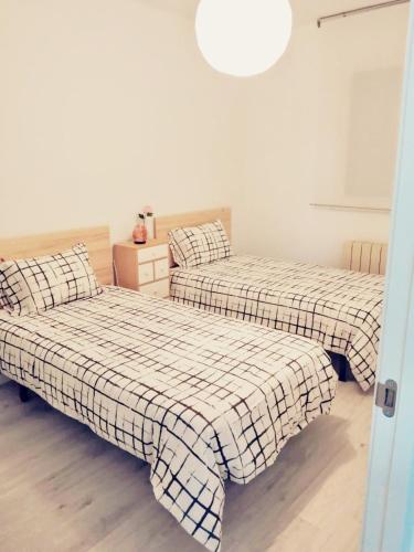 een slaapkamer met 2 bedden en een licht bij Apartamento Bornos&Huesca in Huesca