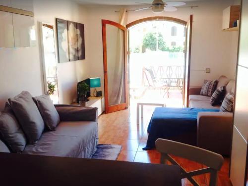 een woonkamer met een bank, een tafel en een raam bij STUDIO TAGORO in Costa Del Silencio