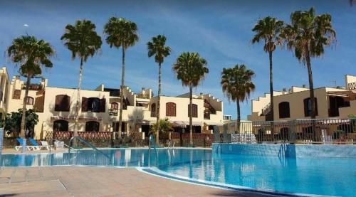 een zwembad met palmbomen op de achtergrond bij STUDIO TAGORO in Costa Del Silencio