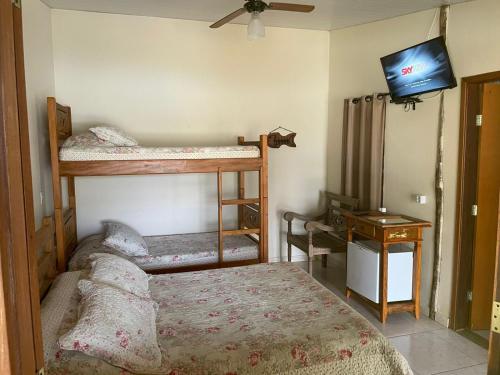 - une chambre avec 2 lits superposés et une télévision à écran plat dans l'établissement Pousada e Restaurante do Porto, à São João Batista do Glória