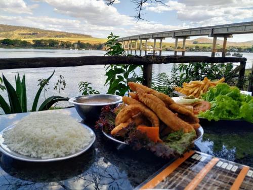 une plaque de nourriture avec du riz et une plaque de nourriture dans l'établissement Pousada e Restaurante do Porto, à São João Batista do Glória