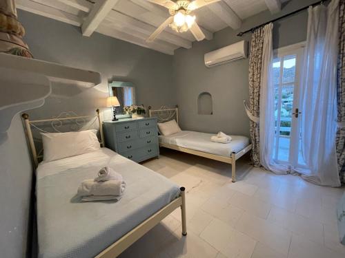 a bedroom with two beds and a window at Kalafatis Private Villa Mykonos in Kalafatis