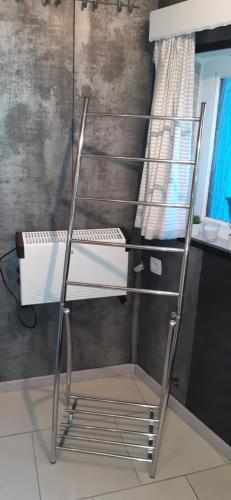 a metal shelf in a bathroom with a sink at LA P'TITE MAISON in Charleroi
