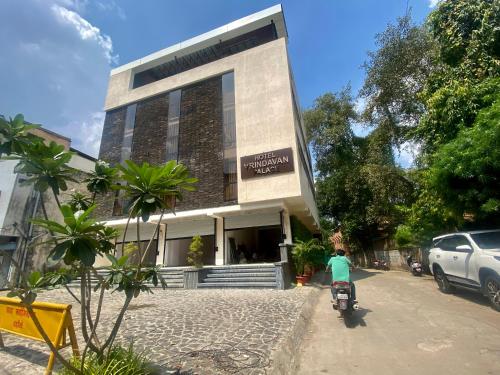 a person riding a scooter in front of a building at Hotel Vrindavan Palace in Indore