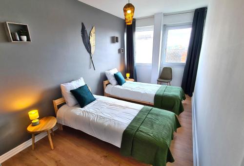 une chambre avec deux lits et une table et une fenêtre dans l'établissement Appartement Mâcon Centre T4 - 100m2, à Mâcon