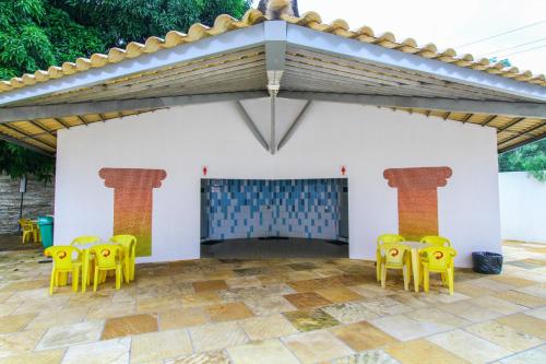 a patio with yellow chairs and a fireplace at Villas diRoma com um dia no Acqua Park, Splash e Slide in Caldas Novas