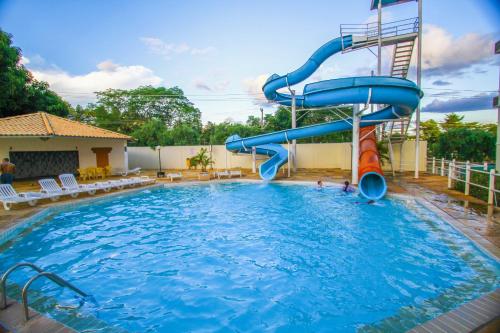 a blue water slide in a swimming pool at Villas diRoma com um dia no Acqua Park, Splash e Slide in Caldas Novas