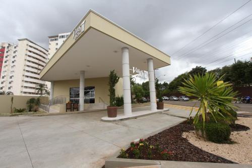a white building with columns on a street at Villas diRoma com um dia no Acqua Park, Splash e Slide in Caldas Novas