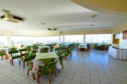 a dining room with tables and chairs and windows at Villas diRoma com um dia no Acqua Park, Splash e Slide in Caldas Novas