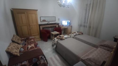 a bedroom with two beds and a desk and a chair at Locanda 130 in Fonni
