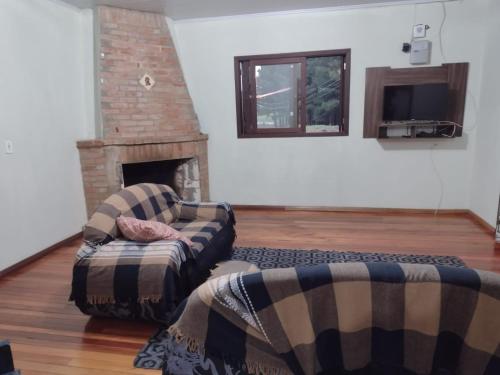 a living room with two couches and a fireplace at Casa de Campo - Cambará do Sul in Cambara do Sul