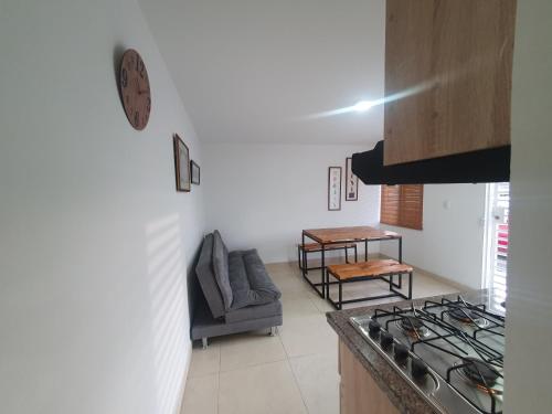 a kitchen with a stove and a couch in a room at Buga Apartamento in Buga