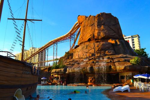 a group of people swimming in a pool in a water park at Villas diRoma com um dia no Acqua Park, Splash e Slide in Caldas Novas