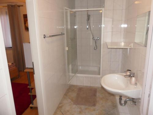 uma casa de banho com um chuveiro e um lavatório. em Hotel Akropolis em Herford