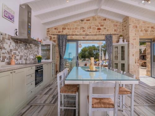 a kitchen with a table and chairs with a view of the ocean at Villa Daniela - Private Pool and Serene Location, by ZanteWize in Koríthion