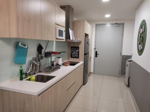 a kitchen with a sink and a refrigerator at HIJAU Geniehome 2BR1studio Free 99mbps WIFI and Carpark at Utropolis Shah Alam in Shah Alam