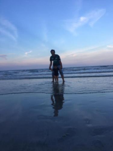 two people standing in the water on the beach at COMEL SEA VIEW HOMESTAY in Kuantan