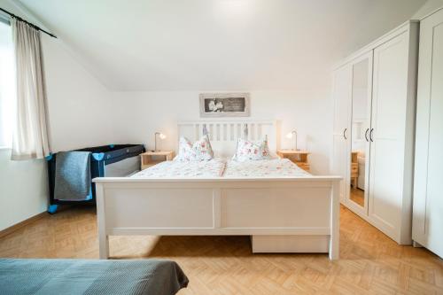 ザンクト・ギルゲンにあるFerienwohnung NINAの白いベッドルーム(ピンクの枕が付いた白いベッド付)