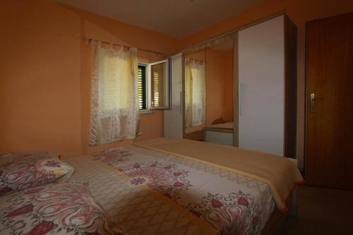 a small bedroom with a bed and a window at Holiday house Lovre in Prapatnica