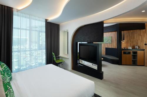 a bedroom with a bed and a flat screen tv at Al Khoory Sky Garden Hotel in Dubai