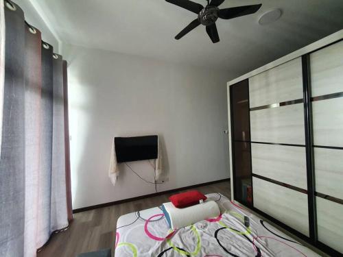 - une chambre avec un lit et un ventilateur de plafond dans l'établissement JB Perling New Cozy Studio, à Johor Bahru