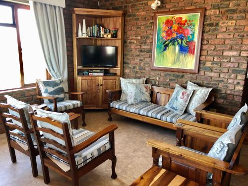 a living room with a couch and chairs and a tv at Magdamol holiday home in Witsand