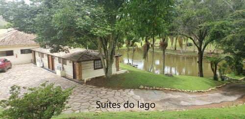 a house next to a pond with a house at POUSADA PARAISO DOS TUCANOS in Aiuruoca