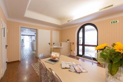ein Esszimmer mit einem Tisch und einer Vase aus Blumen in der Unterkunft Ristorante Hotel Lucia - 100 mt dal mare in Giulianova
