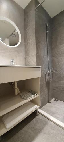 a bathroom with a shower with a sink and a mirror at In Fengchia in Taichung