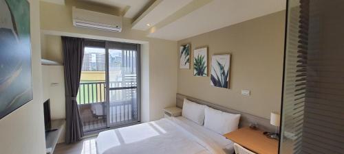 a bedroom with a bed and a balcony at In Fengchia in Taichung
