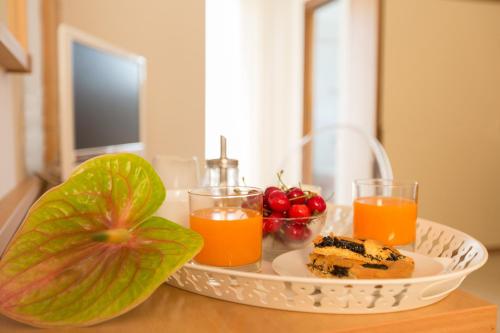 a table with a plate of food and two glasses of orange juice at Ristorante Hotel Lucia - 100 mt dal mare in Giulianova