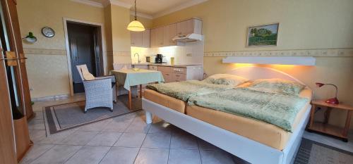 een slaapkamer met een bed en een keuken met een tafel bij Gästehaus Jacobs in Bliesdorf