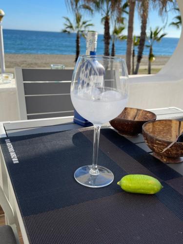 カレタ・デ・ベレスにあるCasa Haisea 2のビーチのそばのテーブルに座るグラスワイン