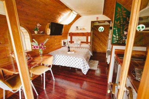a room with a bed and a table and a television at Glamping Cabañas Sharmont in Guarne