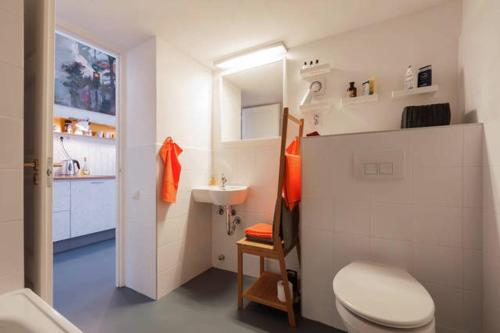 a white bathroom with a toilet and a sink at Stylish holiday Art apartment - wifi & great location in Budapest