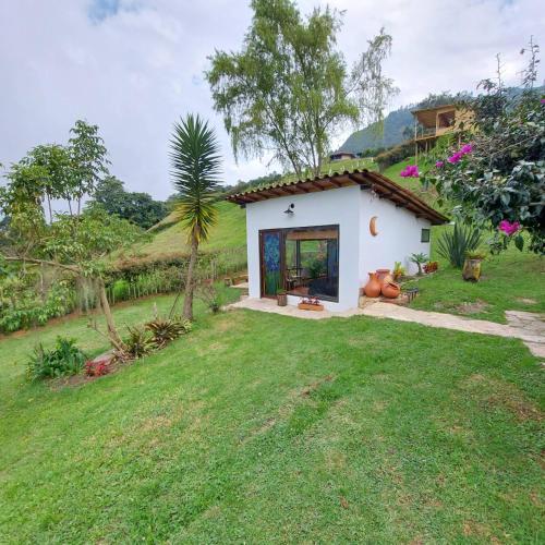a small white house with a grass yard at Naturaleza en armonia in San Francisco