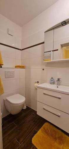 een witte badkamer met een toilet en een wastafel bij Gästehaus Jacobs in Bliesdorf