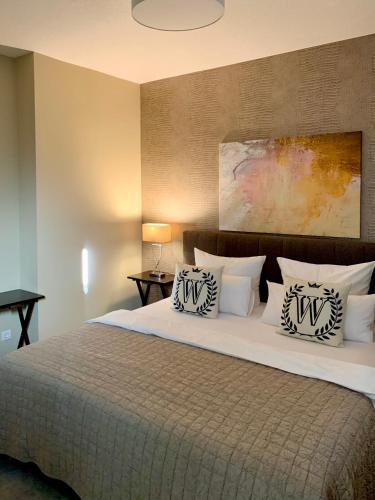 a bedroom with a large bed with two pillows on it at Ambiente Apartments in Naumburg