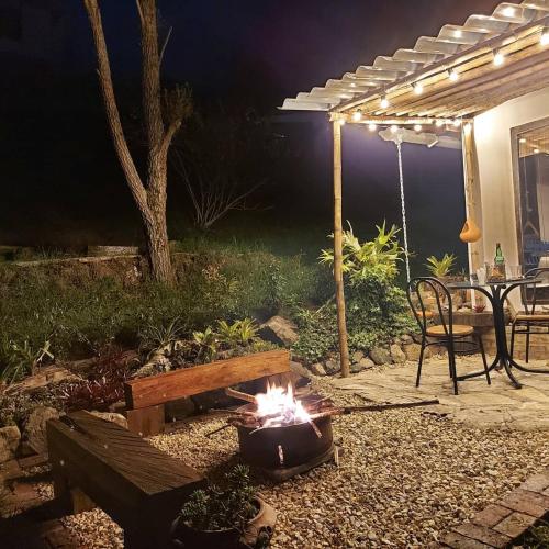 a fire pit in a backyard at night with a table and bench at Naturaleza en armonia in San Francisco